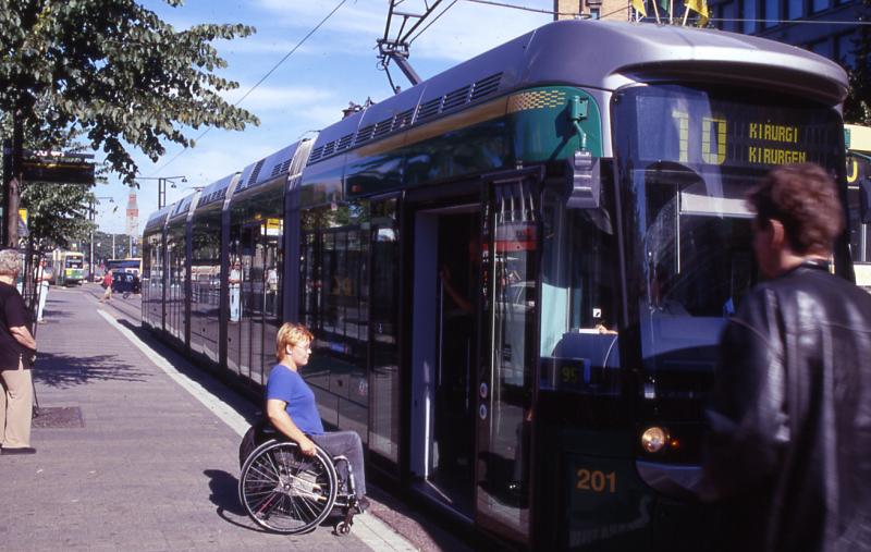 Pyörätuolissa istuva nainen on nousemassa raitiovaunuun numero 10.