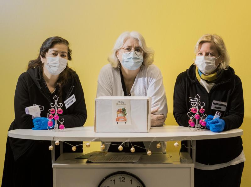 Jaana Berg, Carita Lindbom ja Virpi Lindfors seisovat aulapöydän takana maskit kasvoillaan.